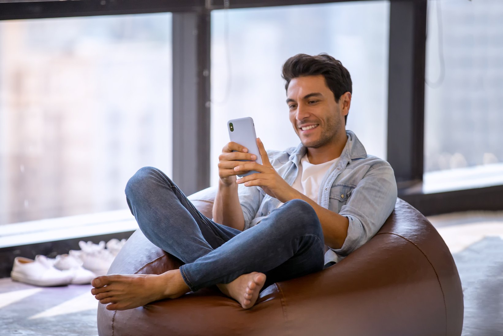 Man Using Mobile Phone Sitting on a Bean Bag